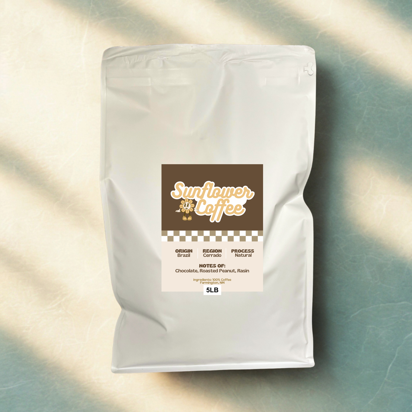 Sunflower Coffee bag on a textured surface with sunlight casting shadows